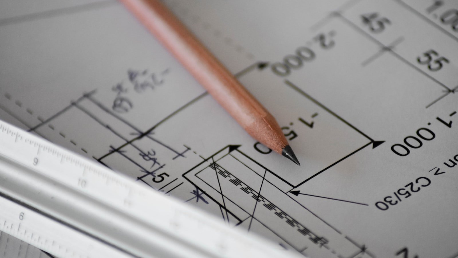 Technical drawing with dimension callouts, pencil, and ruler